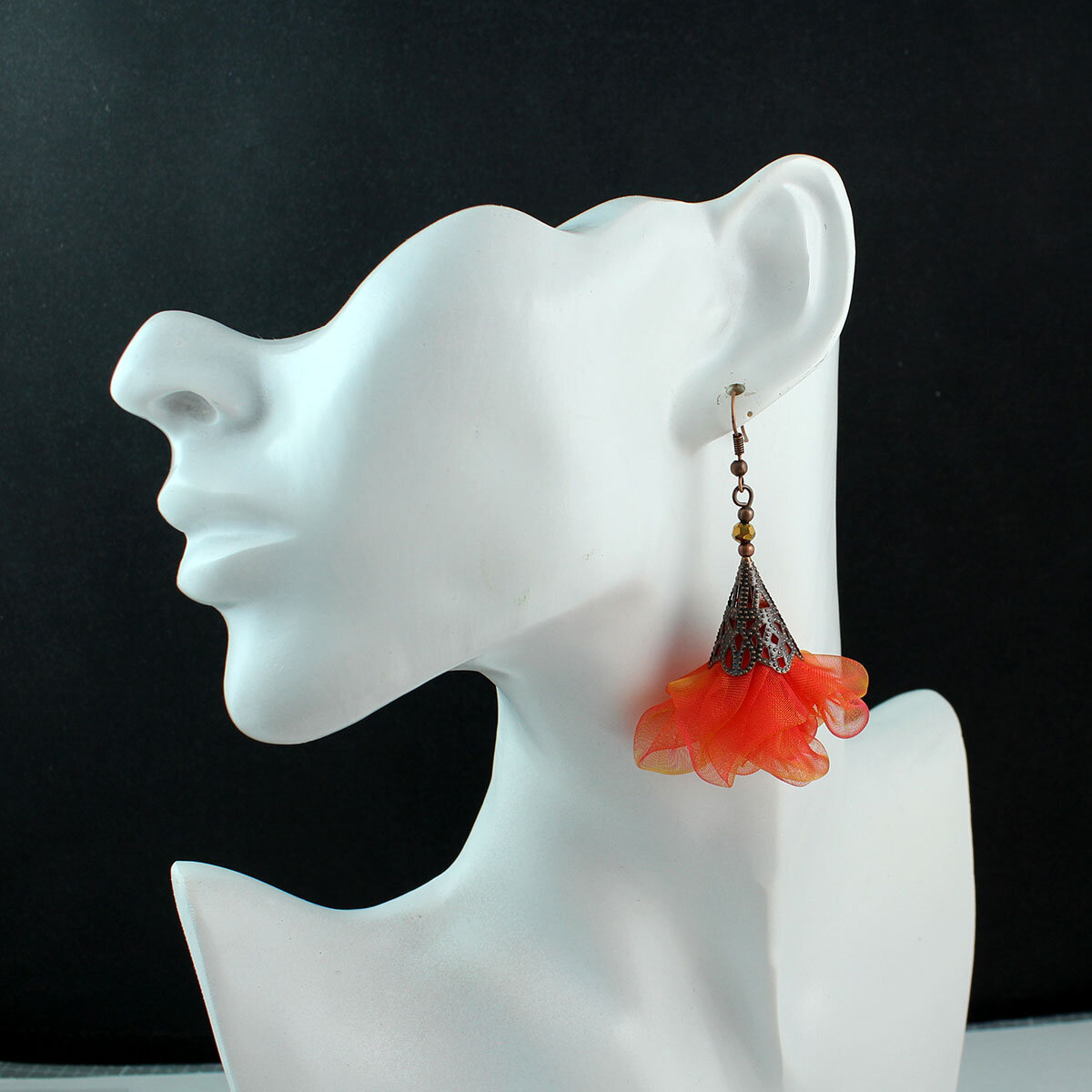 Długie pomarańczowo-różowe kolczyki kwiaty z miedzianym ażurowym elementem.