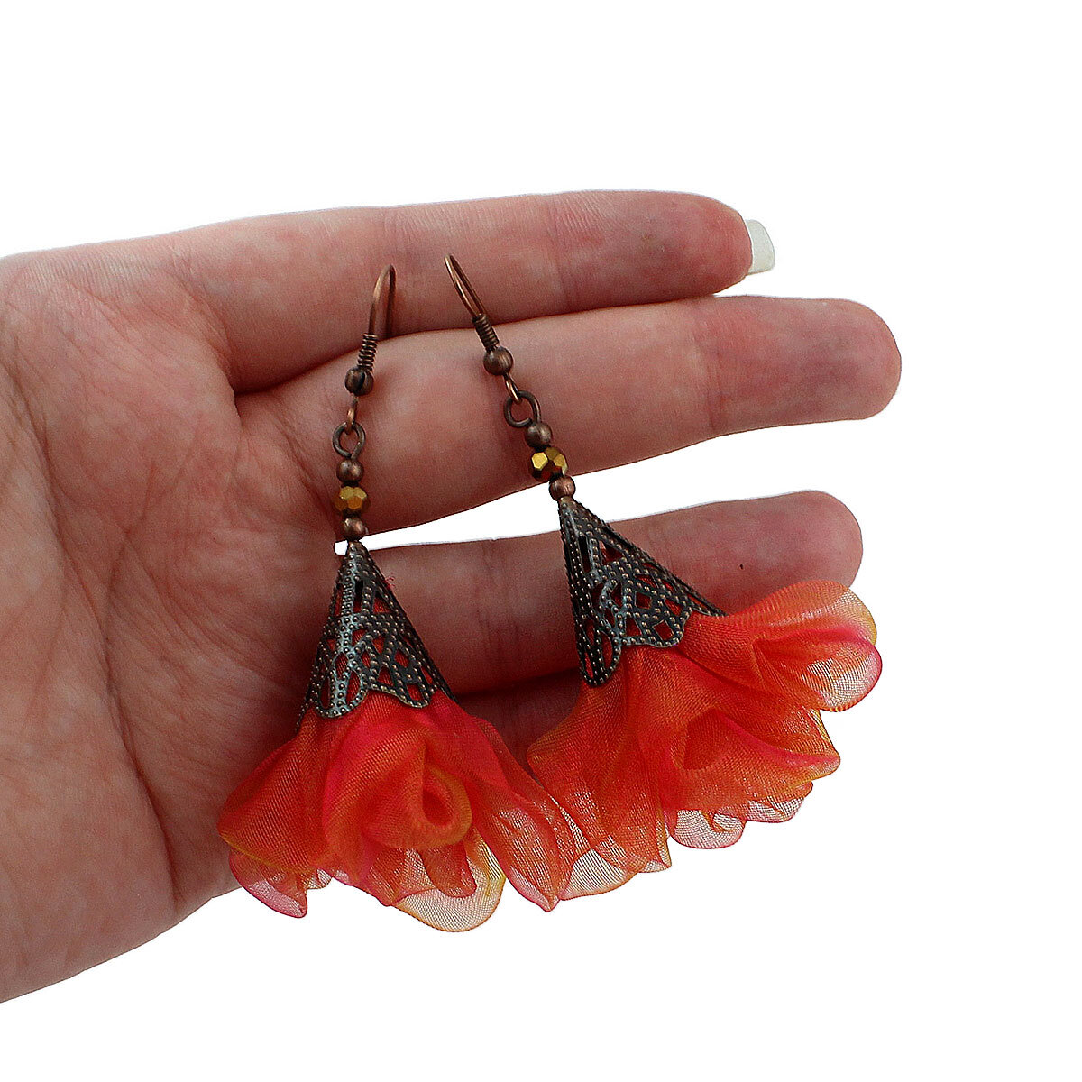 Długie pomarańczowo-różowe kolczyki kwiaty z miedzianym ażurowym elementem.