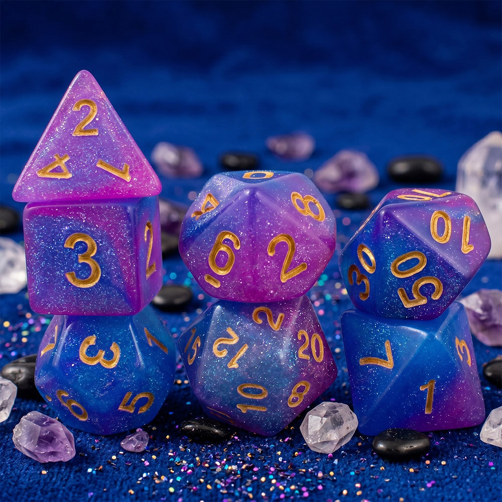 Zestaw brokatowych kości RPG Astro Dust w kolorach niebieskim i fioletowym ze złotymi cyframi.
