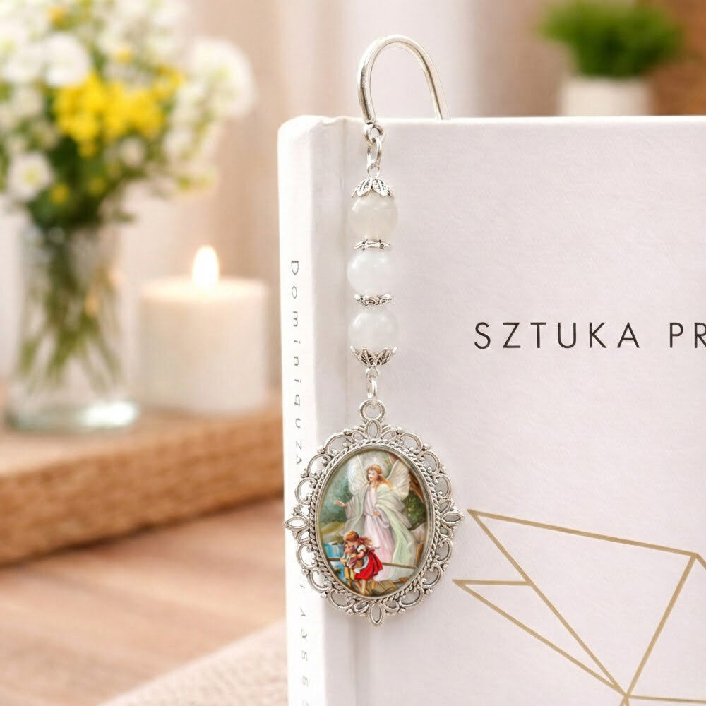 Srebrna zakładka do książki zdobiona motywem roślinnym, z zawieszką z kamieni białego jadeitu i wizerunkiem Anioła Stróża z dziećmi pod szklanym kaboszonem
