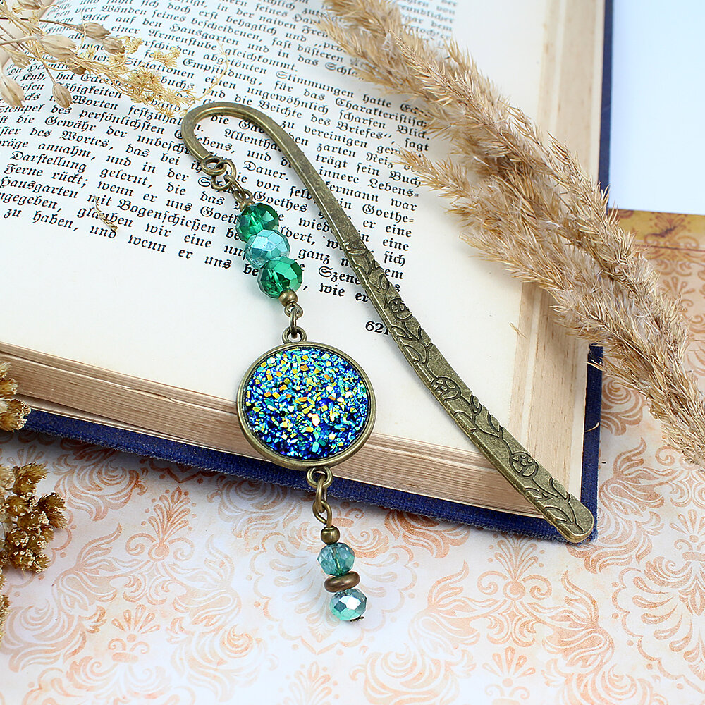 Zakładka do książki mieniąca druza z żywicy kryształki Zakładka do książki z antycznego brązu z motywem roślinnym, zielonymi kryształkami i mieniącą się, błyszczącą druzą z żywicy