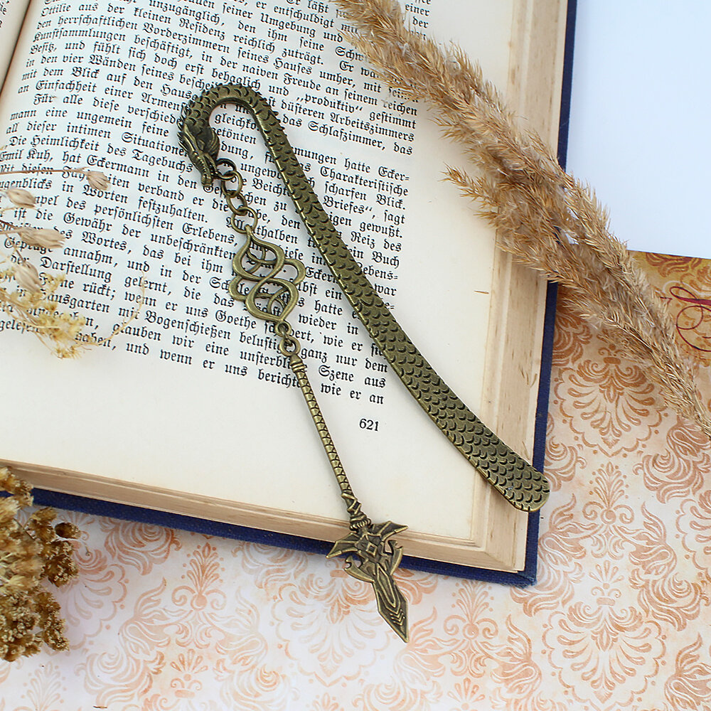 Zakładka do książki włócznia smok broń fantasy Zakładka do książki z antycznego brązu z motywem łusek smoka i zawieszką w kształcie dużej, zdobionej włóczni w stylu fantasy.