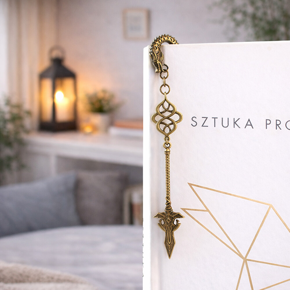 Zakładka do książki włócznia smok broń fantasy Zakładka do książki z antycznego brązu z motywem łusek smoka i zawieszką w kształcie dużej, zdobionej włóczni w stylu fantasy.