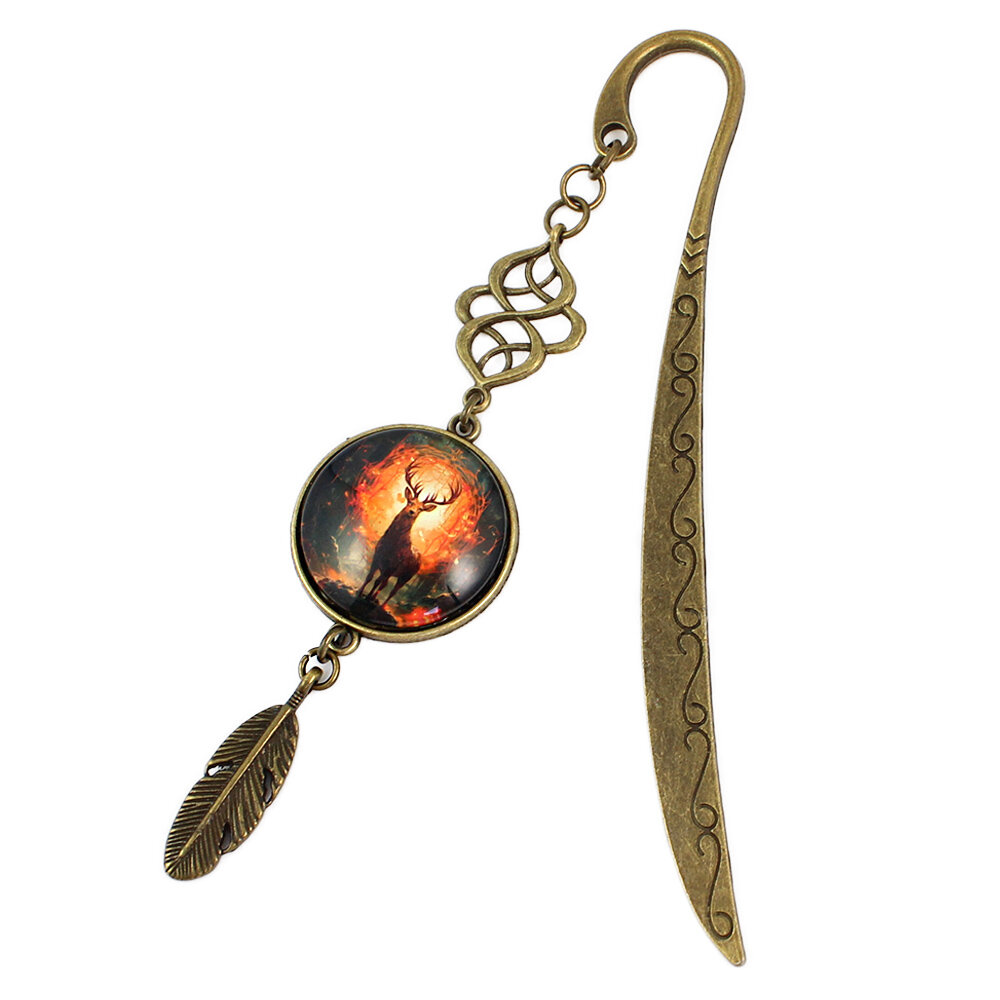 Zakładka do książki z antycznego brązu z ozdobnym falistym trzonem, zawieszką z piórkiem i ilustracją jelenia w ognistym lesie pod kaboszonem.