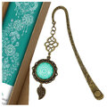 Zakładka do książki z antycznego brązu o falistym trzonie, z ozdobnym koralikiem i uspokajającą, turkusową mandalą pod szklanym kaboszonem. Zakładka do książki z antycznego brązu o falistym trzonie, z ozdobnym koralikiem i uspokajającą, turkusową mandalą pod szklanym kaboszonem.