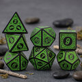 Zestaw czarno-zielonych kości RPG Verdant Arcane z ozdobnymi grawerowanymi ramkami.