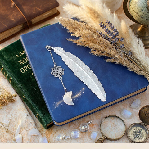 Cienka srebrna zakładka do książki pióro z zawieszką z kryształu górskiego w kształcie księżyca i ażurową rozetką w ozdobnym pudełku.