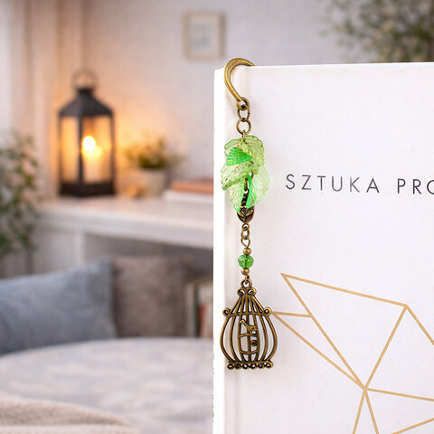 Zakładka do książki z antycznego brązu z zawieszką w kształcie ptaszka w klatce, akrylowymi listkami i szklanym koralikiem.