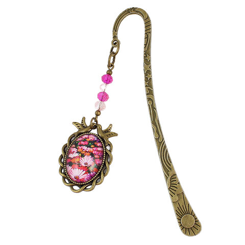 Zakładka do książki z antycznego brązu z różowymi kryształkami i owalnym szklanym kaboszonem z grafiką ptaszków i kwiatów na łące.