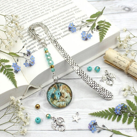 Srebrna zakładka do książki z trzonem w kształcie smoka, szklanymi kryształkami oraz zawieszką z grafiką śpiącej księżniczki i smoka Srebrna zakładka do książki z trzonem w kształcie smoka, szklanymi kryształkami oraz zawieszką z grafiką śpiącej księżniczki i smoka