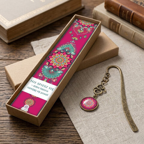 Zakładka do książki z antycznego brązu z niebieskimi koralikami i wielobarwną, harmonijną mandalą pod wypukłym szkiełkiem. Zakładka do książki z antycznego brązu z niebieskimi koralikami i wielobarwną, harmonijną mandalą pod wypukłym szkiełkiem.