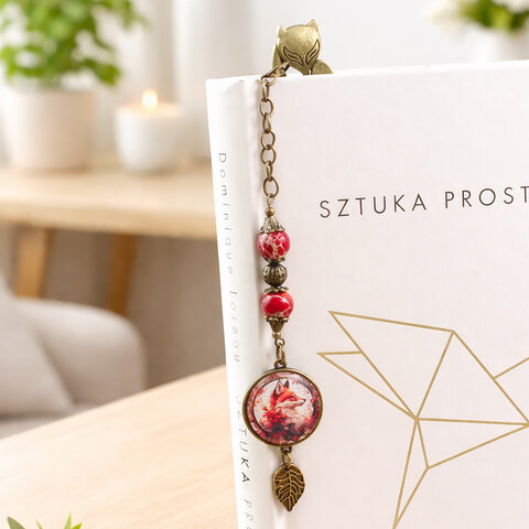 Metalowa zakładka do książki w kształcie ozdobnego lisa w kolorze antycznego brązu z jaspisem cesarskim i grafiką lisa pod szkłem.