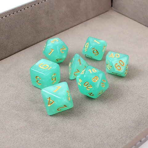 Turkusowe kości wielościenne do RPG ze złotymi cyframi i połyskiem.